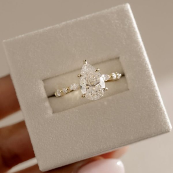 This pear doesn’t fall far from perfection. Beautifully accented with round and marquise stone